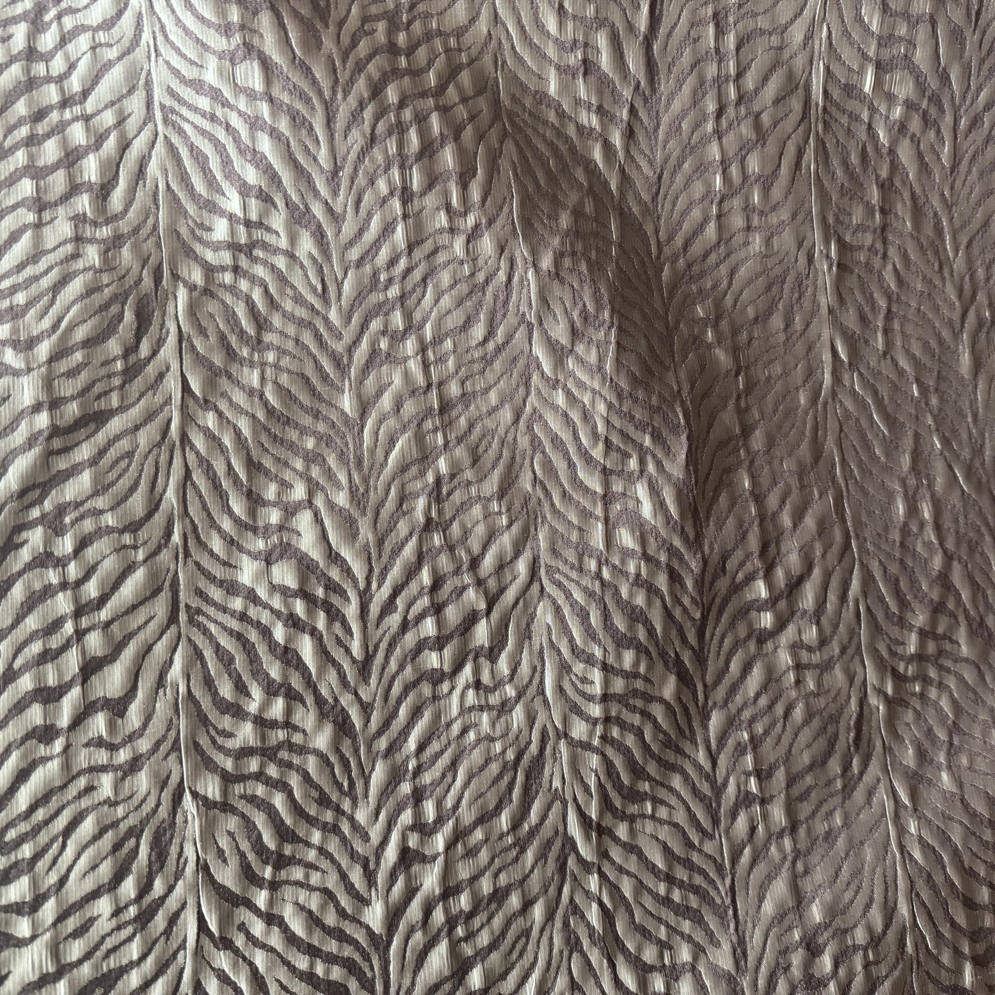 Textured fabric with a pattern resembling feathers on a neutral background