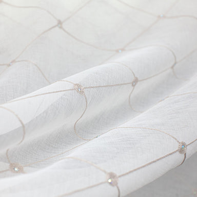Cream lightweight sheer fabric with a refined texture, ideal for curtains and drapery. High-quality and stylish for any space.